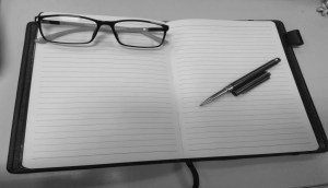 a pair of glasses and pen on a journal